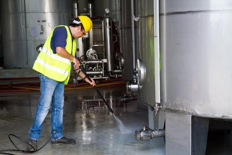 A man power-washing a floor